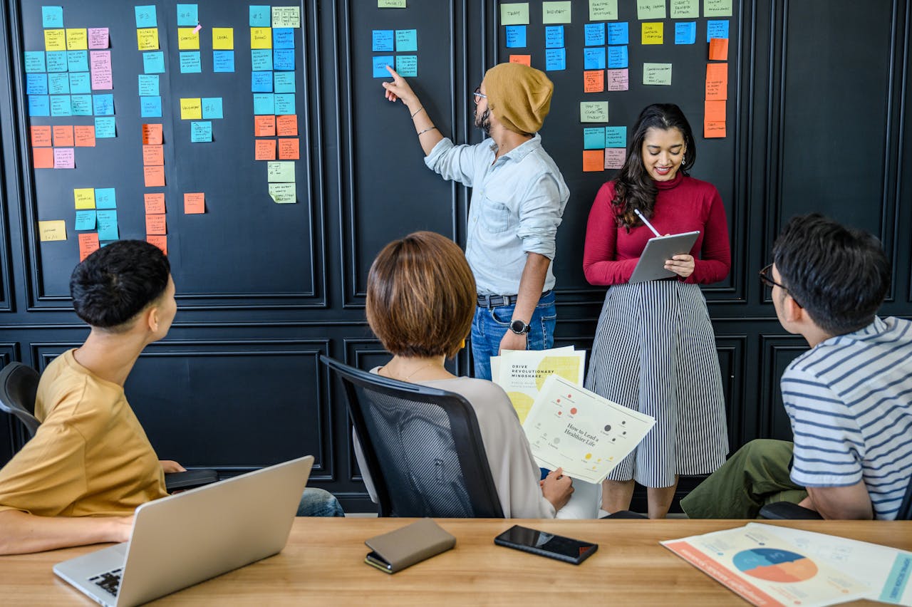 A diverse group collaborating with sticky notes in a modern office setting, fostering creativity and teamwork.